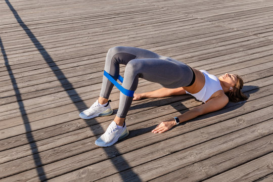 Girl doing exercises on wooden foor outdoors,