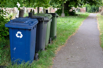 Series of plastic wheelie bins seen at a churchyard for the disposal of flowers and other items.