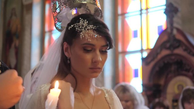 Close-up portrait of bride in the Orthodox Church during the wedding ceremony.
