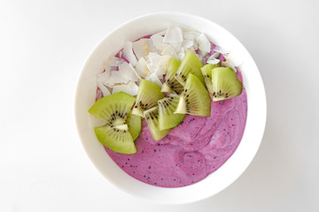 berry smoothie bowl with kiwi and coconut slices
