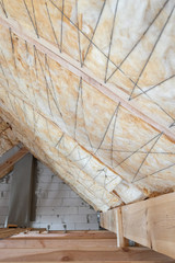 House under construction with insulation glass wool on an attic floor