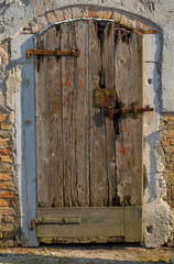 Old wooden door with rusty handle. Texture of wood and wall. Background photo. Travel photo. Venice. Italy.