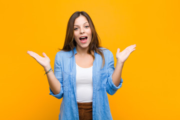 young pretty woman feeling happy, excited, surprised or shocked, smiling and astonished at...