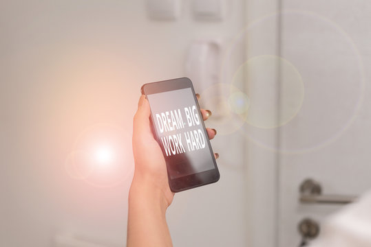 Word writing text Dream Big Work Hard. Business photo showcasing Believe in yourself and follow the dreams and goals woman using smartphone office supplies technological devices inside home