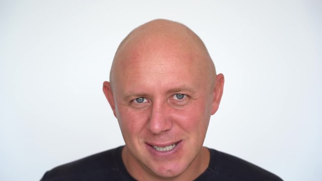 Closeup shoot of middle-aged caucasian bald man looking at camera. People and lifestyle concept. Portrait of middle aged man indoors