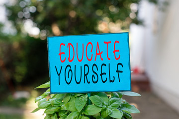 Text sign showing Educate Yourself. Business photo text prepare oneself or someone in a particular area or subject Plain empty paper attached to a stick and placed in the green leafy plants