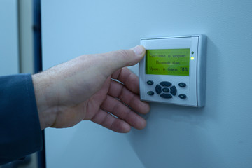 Worker’s hand touching control board of the electrolysis units set in the hall of the disinfecting water at the pumping station