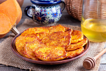 Pumpkin pancakes with honey on a plate