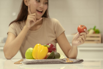 Fototapeta premium Young beautiful woman take care her health by eating salad and fruit instead of eating fat and calories