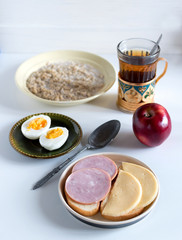 Schoolboy breakfast with porridge and sandwiches. Schoolboy nutrition concept.