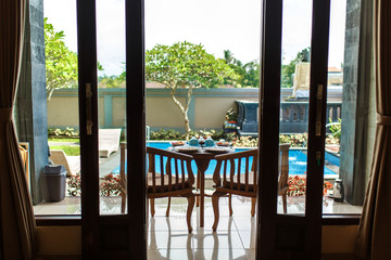 View from the room, Balinese tropical breakfast of fruit, coffee and omelet for two people. on the background of the pool