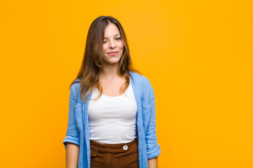 young pretty woman looking happy and friendly, smiling and winking an eye at you with a positive...