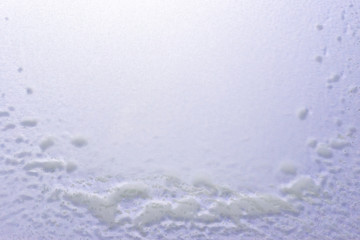 Abstract winter background, frozen glass covered with snow.
