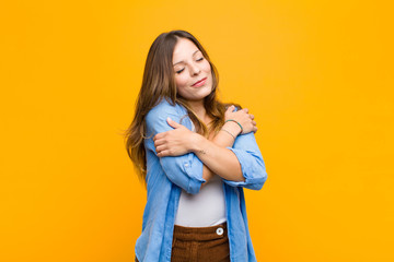 young pretty woman feeling in love, smiling, cuddling and hugging self, staying single, being...