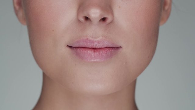 Close-up portrait of young, beautiful and natural woman opening her mouth and smiling. Face lifting, cosmetics and make-up.