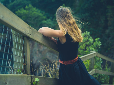 Young woman relaxing by railing in nature