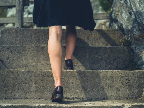 Legs of a young woman walking up some steps outside