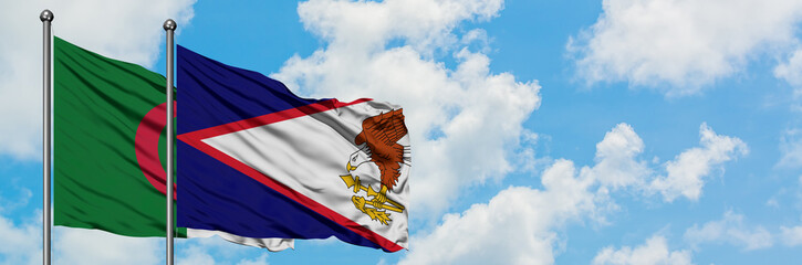 Algeria and American Samoa flag waving in the wind against white cloudy blue sky together....