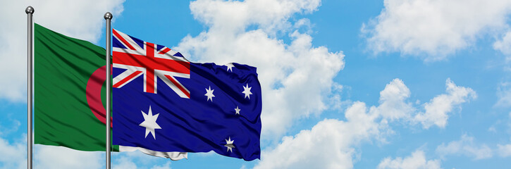 Algeria and Australia flag waving in the wind against white cloudy blue sky together. Diplomacy...
