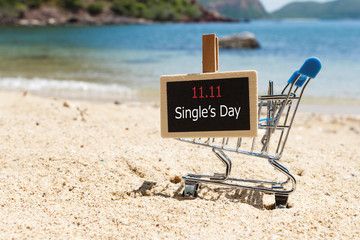 Online shopping of China, 11.11 single's day sale concept. The shopping cart and the text 11.11 single's day sale on the beach.