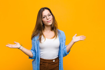 young pretty woman feeling puzzled and confused, unsure about the correct answer or decision,...
