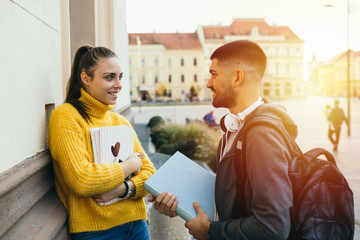 couple of students talking beside campus building outdoors