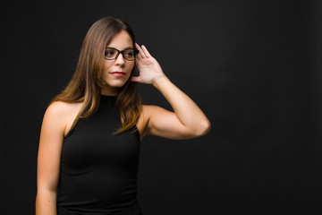 young pretty woman looking serious and curious, listening, trying to hear a secret conversation or...