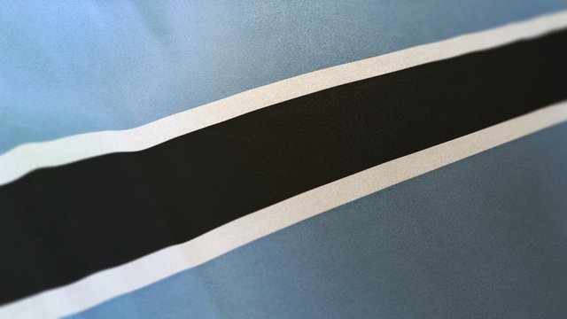 locked full-screen close shot of the national flag of Botswana. The banner/emblem is made of realistic satin texture and rendered in a daylight situation. T