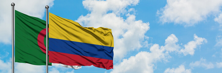 Algeria and Colombia flag waving in the wind against white cloudy blue sky together. Diplomacy...