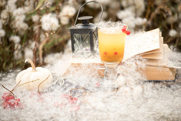 lantern with a candle and tea inside among white fluffs. fabulous magical photo.  autumn cozy still life.