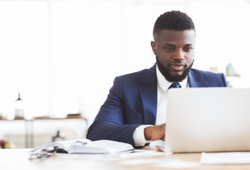 Concentrated businessman working with laptop in office