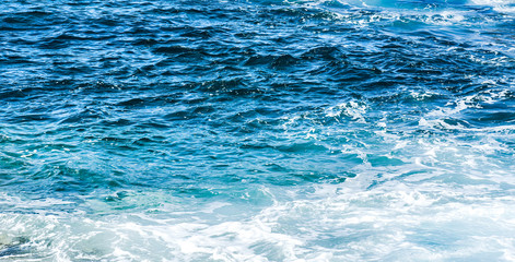 Rough sea or ocean foam. Blue salt water waves background.