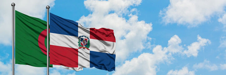 Algeria and Dominican Republic flag waving in the wind against white cloudy blue sky together. Diplomacy concept, international relations.