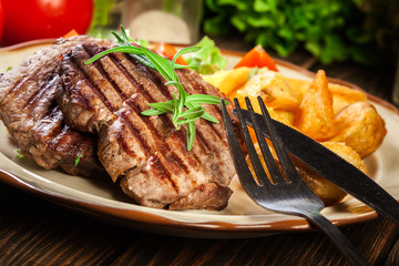 Succulent portions of grilled fillet mignon served with baked potatoes