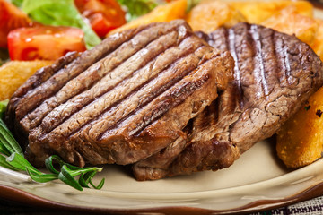 Succulent portions of grilled fillet mignon served with baked potatoes