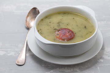 typical portuguese soup caldo verde in white bowl on ceramic background