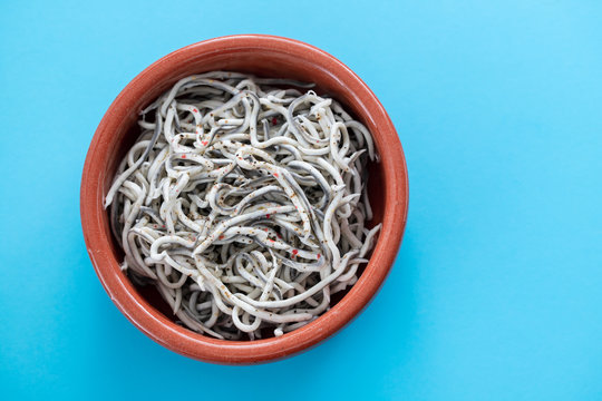 Traditional Spanish food. Gulas with oil in ceramic dish.