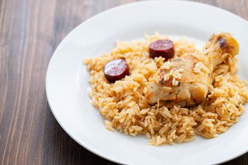 chicken with smoked sausage and rice on white plate