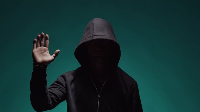 Portrait of computer hacker in hoodie. Obscured dark face. Data thief, internet fraud, darknet and cyber security .