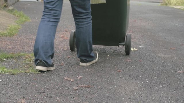 Moving green recycling wheelie bin for waste collection