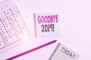 Text sign showing Goodbye 2019. Business photo showcasing express good wishes when parting or at the end of last year White pc keyboard with empty note paper and pencil above white background