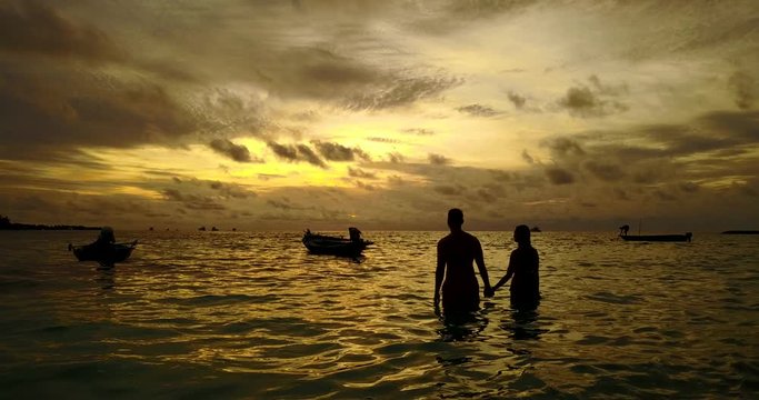 Young couple watch the sunset in the ocean