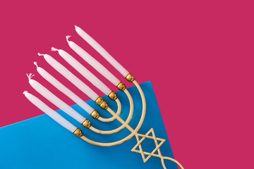Jewish Hanukkah menorah on pink and blue background