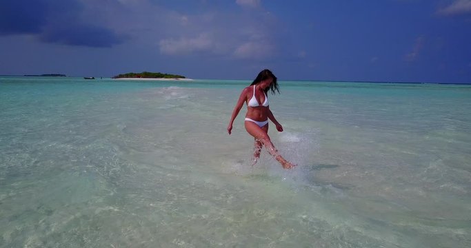 Aerial Of Beautiful Young Woman In Bikini Enjoying Luxury vacation on tropical island with white sand beach