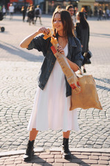Beautiful girl eat baguette on the street