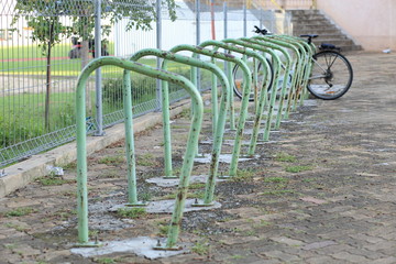 Fototapeta na wymiar Green steel frame for parking bicycles in public park.