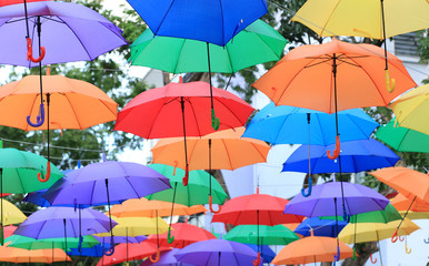 Fototapeta na wymiar Street decorated with colorful umbrellas. Multi colored umbrellas is beautiful for background.