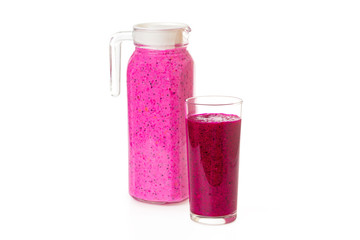Jug and glass of fresh healthy layered dragon fruit smoothie with coconut milk isolated at white background. Concept of detox and vegan healthy lifestyle.