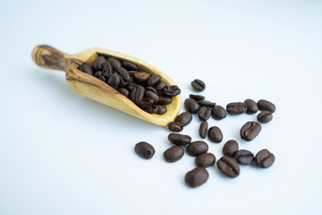 Coffee bean and wooden scoop isolated on white background with great texture and ambiance for design material or elements