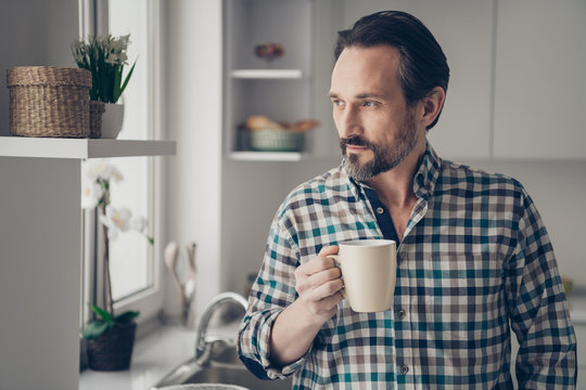 Close up photo portrait of optimistic thinking imaging his future guy holding cup of fresh homemade coffee looking in window